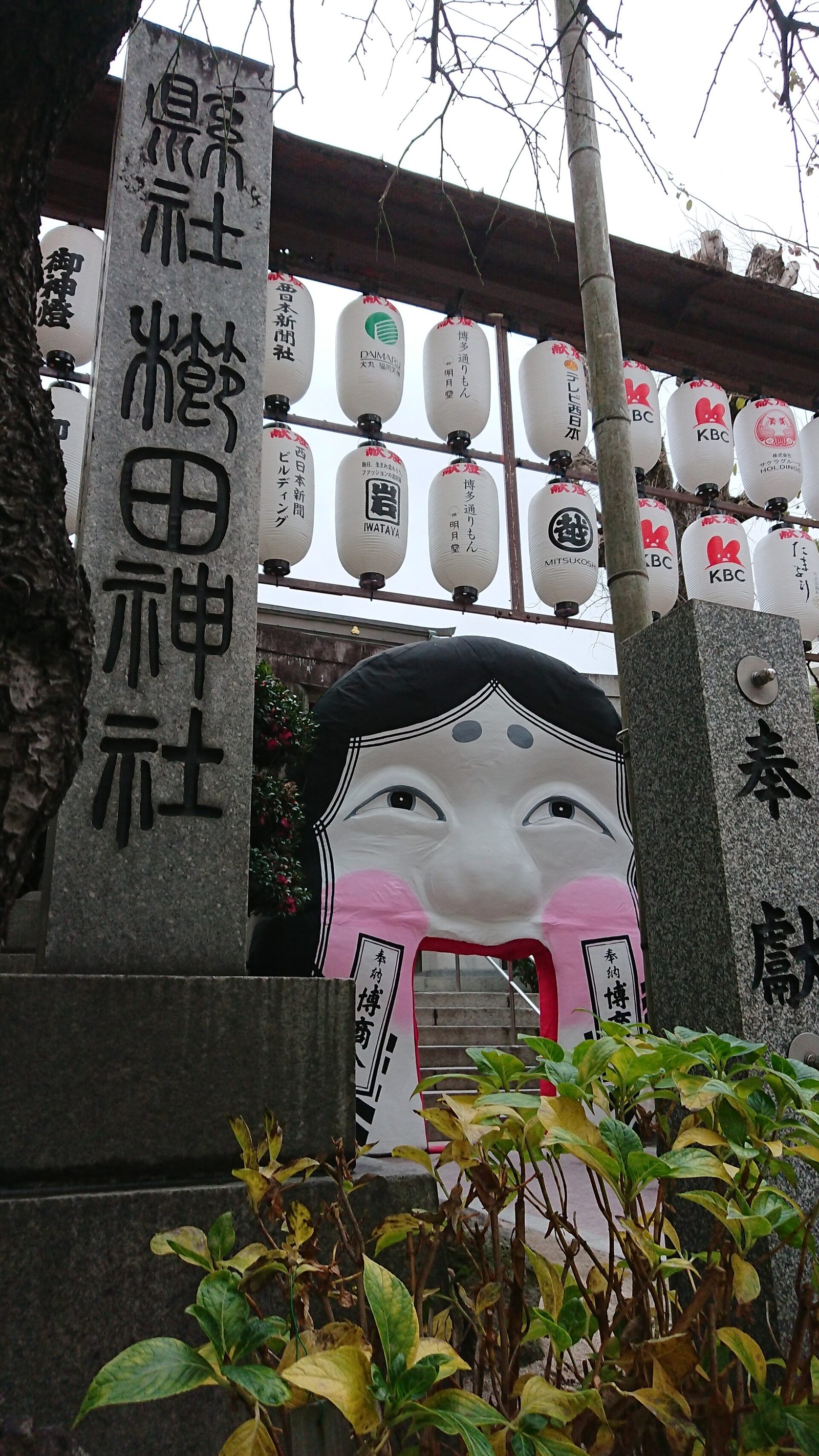 櫛田神社の入口に立つ石柱と奉納提灯