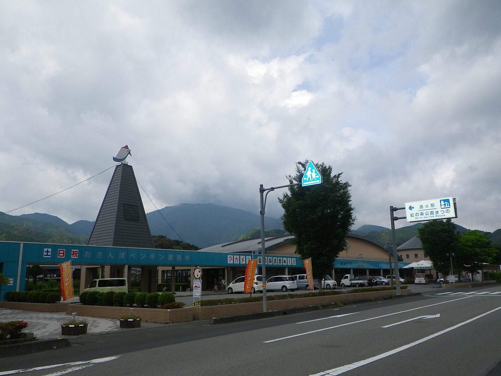 道の駅「虹の森公園まつの」の建物と案内標識。「おさんぽペンギン実施中」の看板が見える