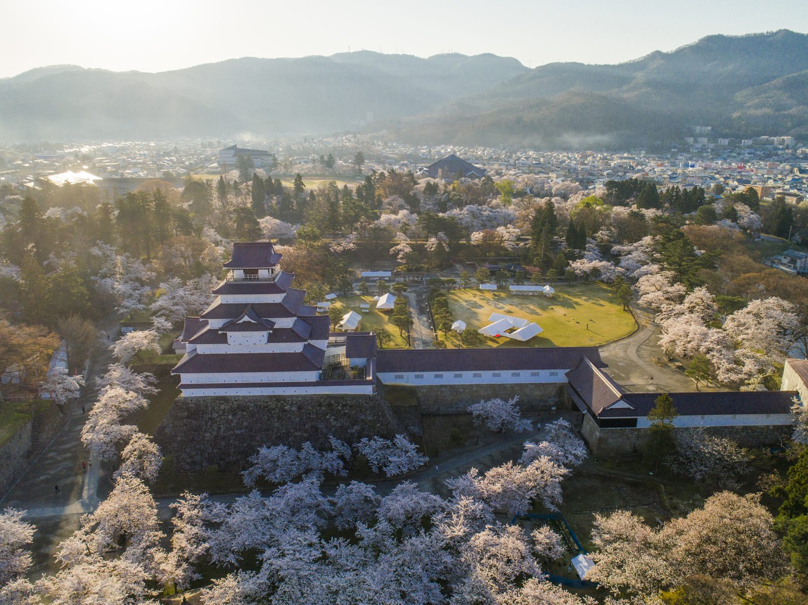 桜に囲まれた鶴ヶ城天守閣の空撮