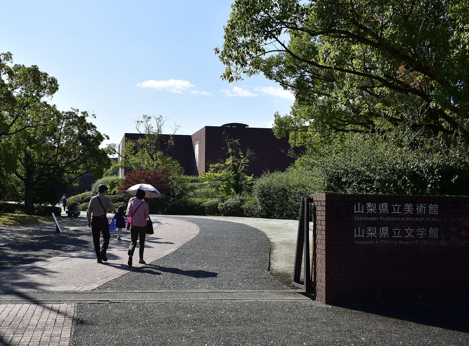 山梨県立美術館の入口看板と園内通路